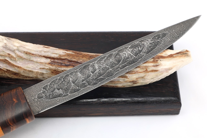 Нож Северный №4 (дамаск, кованый дол, карельская береза янтарная, железное дерево) на подставке